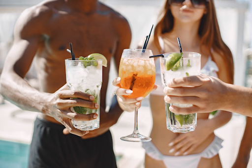 friends drinking cocktails at beach